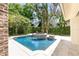 Beautiful backyard pool and spa surrounded by lush landscaping and travertine tile at 952 Moss Ln, Winter Park, FL 32789