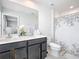 Bright bathroom featuring a double vanity with modern fixtures, a toilet, and shower with patterned curtain at 1508 Majestic Ln, Winter Haven, FL 33880