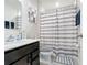 Bathroom featuring a dark vanity, shower with tub, and striped shower curtain at 1508 Majestic Ln, Winter Haven, FL 33880