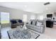 Bright living room showcasing stylish gray sofas, decorative rug, and natural light from windows at 1508 Majestic Ln, Winter Haven, FL 33880