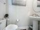 Neat half-bathroom featuring a pedestal sink, tiled floor, and decorative art at 1508 Majestic Ln, Winter Haven, FL 33880