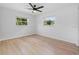 Bright bedroom with two windows, a ceiling fan, and light wood-look flooring at 19795 Sw 85Th Loop, Dunnellon, FL 34432