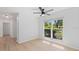 Bright bedroom with a ceiling fan and large window providing a view of the greenery outside at 19795 Sw 85Th Loop, Dunnellon, FL 34432