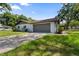 Spacious two-car garage with driveway, blending functionality with the home's exterior at 19795 Sw 85Th Loop, Dunnellon, FL 34432