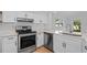 Modern kitchen featuring stainless steel appliances, white cabinets and quartz countertops at 19795 Sw 85Th Loop, Dunnellon, FL 34432