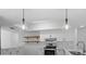 Bright kitchen with white cabinets, stainless steel appliances and stylish pendant lighting at 19795 Sw 85Th Loop, Dunnellon, FL 34432