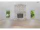 Bright living room with stone fireplace, light hardwood floors, and natural light at 19795 Sw 85Th Loop, Dunnellon, FL 34432