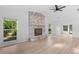 Spacious living room featuring a stone fireplace, hardwood floors, and bright windows at 19795 Sw 85Th Loop, Dunnellon, FL 34432