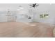 Spacious living room with light wood floors, skylights, a ceiling fan, and views of the kitchen at 19795 Sw 85Th Loop, Dunnellon, FL 34432