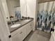 Bathroom features a double sink vanity with granite countertops and decorative shower curtain at 3148 Caspian Feather St, Bartow, FL 33830