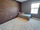 Bedroom with a distinctive brick accent wall, neutral carpet and ample natural light at 3148 Caspian Feather St, Bartow, FL 33830