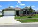 Charming single-story home featuring a two-car garage, lush landscaping, and a well-manicured lawn at 3148 Caspian Feather St, Bartow, FL 33830
