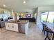 Open-concept kitchen featuring granite countertops, stainless steel appliances, and an island with a breakfast bar at 3148 Caspian Feather St, Bartow, FL 33830