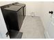 Modern laundry room with black washer and dryer, and sleek tiled floors at 3148 Caspian Feather St, Bartow, FL 33830
