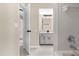 Hallway view of remodeled bathroom with neutral walls and floors, gray cabinets and shower/tub combo at 3331 Lime Tree Dr, Edgewater, FL 32141