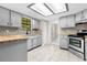 Open kitchen with shaker cabinets, mosaic backsplash, tiled floors and stainless steel appliances at 3331 Lime Tree Dr, Edgewater, FL 32141