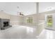 Spacious living room with a brick fireplace, tile floors, a ceiling fan, and a large window for natural light at 3331 Lime Tree Dr, Edgewater, FL 32141