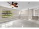 Bright living room featuring tile floors, a large window, and a ceiling fan with decorative leaf-shaped blades at 3331 Lime Tree Dr, Edgewater, FL 32141