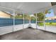 A concrete lanai with white screens and a white metal fence provides an enclosed view of the backyard at 3331 Lime Tree Dr, Edgewater, FL 32141