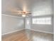 Spacious living room showcasing wood floors, a ceiling fan, and large windows for natural light at 3550 Keen Dr, Mulberry, FL 33860