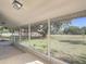 The screened-in porch offers views of the large yard and mature shade trees at 3550 Keen Dr, Mulberry, FL 33860