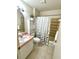 Well-lit bathroom featuring a white vanity, toilet, and a shower-tub combo with stylish shower curtain at 1310 Payne St, Auburndale, FL 33823