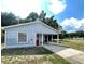 Exterior shot of the residence showing the side carport and front window at 1310 Payne St, Auburndale, FL 33823