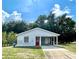 Charming single-story home with a covered carport, red front door, and well-maintained lawn at 1310 Payne St, Auburndale, FL 33823
