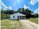 Charming single-story home featuring a bright red front door and a convenient attached carport at 1310 Payne St, Auburndale, FL 33823