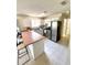 Well-lit kitchen with stainless steel appliances, tile flooring, and a convenient breakfast bar at 1310 Payne St, Auburndale, FL 33823