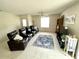 Cozy living room featuring comfortable seating, natural light, and a decorative area rug at 1310 Payne St, Auburndale, FL 33823