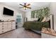 Bedroom with a mounted TV, stylish decor, and leafy vines creating a calming ambiance at 6050 Eagle Pointe Dr, Lakeland, FL 33812