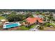 Aerial view showcases a community clubhouse with a pool and manicured landscape at 9755 Se 176Th St, Summerfield, FL 34491