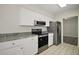 Modern kitchen with stainless steel appliances, white cabinets and granite countertops at 9755 Se 176Th St, Summerfield, FL 34491