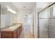 Ensuite bathroom featuring double sinks, granite countertops, and a glass-enclosed shower at 3848 Spirited Cir, St Cloud, FL 34772
