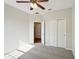 Cozy bedroom with a ceiling fan, plush carpet, closet with sliding doors, and two doorways for easy access at 3848 Spirited Cir, St Cloud, FL 34772