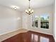 A dining room has hardwood floors, windows for natural light, and an elegant chandelier for ambient lighting at 3848 Spirited Cir, St Cloud, FL 34772