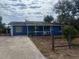 Charming single-story home with a blue exterior, white trim, covered front porch, and mature trees at 45652 Ohio St, Paisley, FL 32767