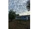 Charming single-story home with a blue exterior, white trim, covered front porch, and mature trees at 45652 Ohio St, Paisley, FL 32767