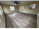 Open-concept living area featuring stylish laminate flooring, neutral walls, a fan, and natural light at 45652 Ohio St, Paisley, FL 32767