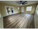 Open-concept living area featuring stylish laminate flooring, neutral walls, a fan, and natural light at 45652 Ohio St, Paisley, FL 32767