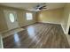 Open-concept living area featuring stylish laminate flooring, neutral walls, a fan, and natural light at 45652 Ohio St, Paisley, FL 32767