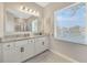 Bright bathroom features a double vanity with granite countertop and a large window at 1803 Daybreak Dr, Fruitland Park, FL 34731