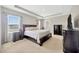 Spacious main bedroom featuring a large window, tray ceilings, and dark wood furnishings at 1803 Daybreak Dr, Fruitland Park, FL 34731