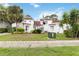 Home featuring lush landscaping, a red tile roof, white stucco, and an American flag at 2524 Albion Ave, Orlando, FL 32833