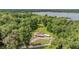 Aerial view of a home surrounded by mature trees with a covered back porch, lean-to and circular driveway at 1611 County Road 753S, Webster, FL 33597