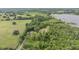 Aerial view of a sprawling property featuring lush greenery, mature trees, a home, and a serene lake in the background at 1611 County Road 753S, Webster, FL 33597