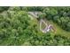 Bird's eye view of a house, pond, and detached garage connected by a looping driveway on a maturely landscaped lot at 1611 County Road 753S, Webster, FL 33597