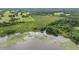 Aerial perspective of a body of water fringed by wetland vegetation, bordered by lush grasslands and abundant trees at 1611 County Road 753S, Webster, FL 33597