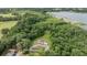 Lakefront property aerial view surrounded by lush trees, featuring a home and detached garage at 1611 County Road 753S, Webster, FL 33597
